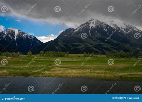 Snow Capped Absaroka Mountains with a Lush Green Field and Lake Near ...