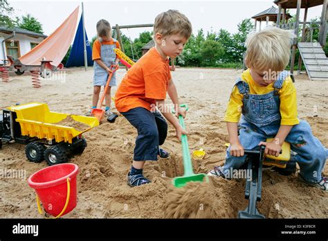 Three children play at the sandbox Stock Photo - Alamy