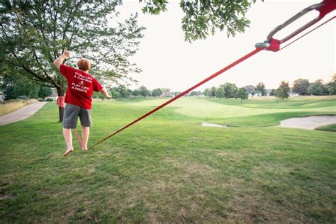 Premium Photo | Rear view full length of man slacklining at park