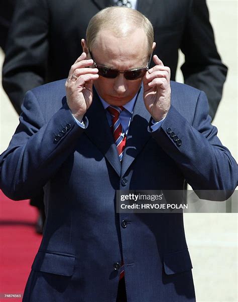 Russian President Vladimir Putin adjusts his sunglasses as he arrives ...