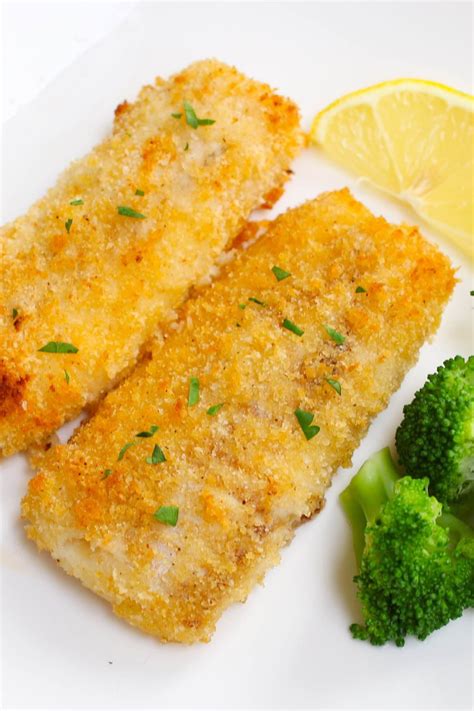 Baked breaded haddock fillets garnished with fresh lemon and served with a side of broccoli ...