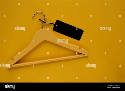 Wooden Coat hanger with black paper label isolated on yellow paper ...