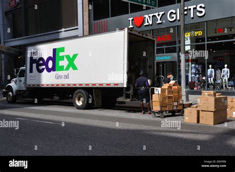 FedEx truck delivery, New York City, USA - driver unloading packages and boxes from the truck ...