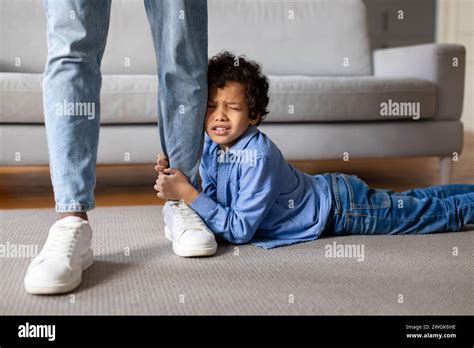 Upset child boy clinging to father's leg at home Stock Photo - Alamy