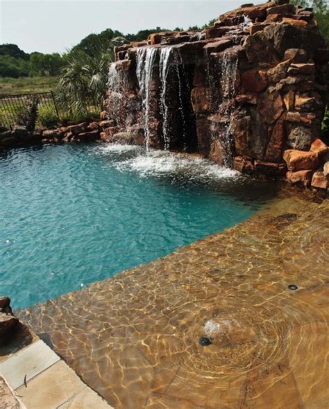 Lagoon style swimming pool with waterfall grotto with spa inside ...