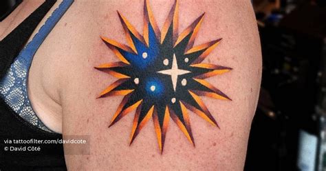 Sun/star tattoo located on the upper arm.