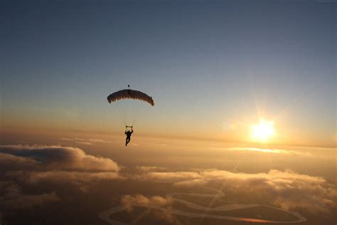 Download A Person Is Flying A Parachute | Wallpapers.com