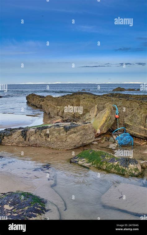 LOSSIEMOUTH MORAY FIRTH SCOTLAND A WINTER WEST BEACH AND A LOBSTER POT ...