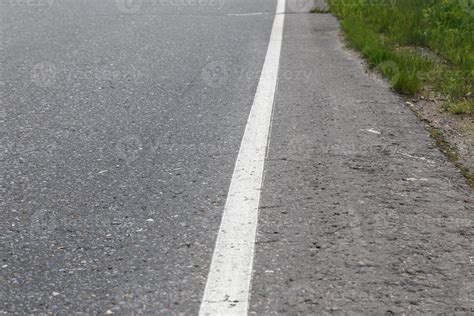 White solid line. Road marking on an asphalt road. selective focus ...