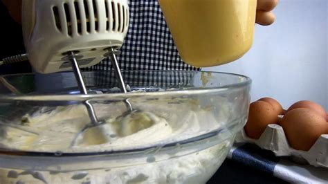 Lady is making homemade cream cake using electric portable mixer ...