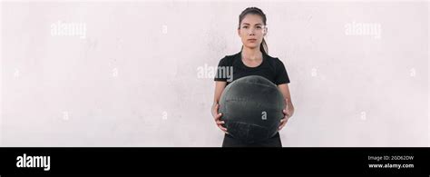 Woman athlete cross training carrying throwing heavy medicine ball doing squats and ball slam ...