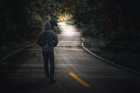 A Man Walking Alone on a Country Road Stock Photo - Image of light ...