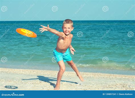 A Child is Playing with a Frisbee on the Beach. Stock Image - Image of ...