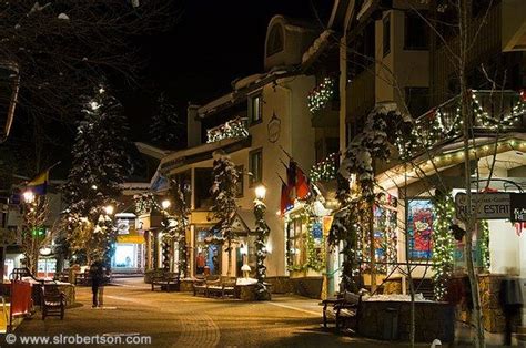 a city street is lit up with christmas lights