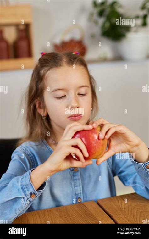 Cute little girl eat red apple at home at kitchen interior, yummy, happy child, Healthy ...