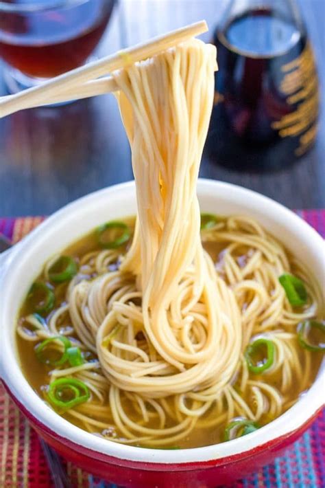 A bowl of quick and easy Chinese noodle soup with chopsticks holding ...