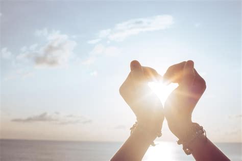 Premium Photo | Woman holds hands up to sky in the shape of a heart