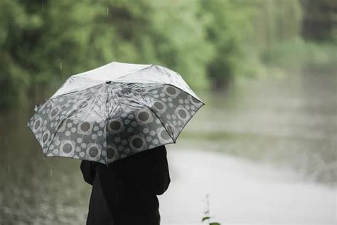 Woman silhouette standing in the rain with an umbrella — Stock Photo © pitika #9556141