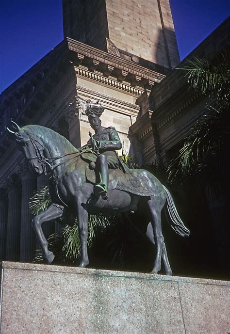 Angled view towards King George V Memorial Statue foregrounded against Brisbane City Hall in ...