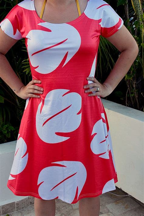 a woman in a red and white dress posing for the camera with her hands on her hips