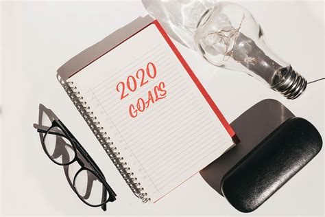 Top view of office desk with glasses and notebook with 2020 goals. New year concept. - Creative ...