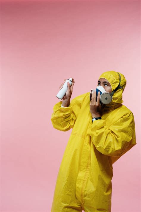 Man in Yellow Coveralls Holding Spray Bottle · Free Stock Photo