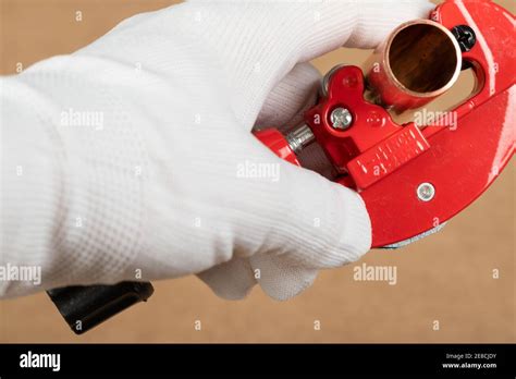 Cutting a copper pipe with a red pipe cutter Stock Photo - Alamy