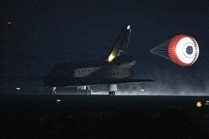 In rare night landing, space shuttle back on Earth