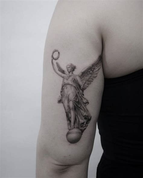 Micro-realistic Nike goddess tattoo on the tricep.