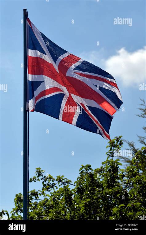 fluttering union jack flag on flagpole Stock Photo - Alamy