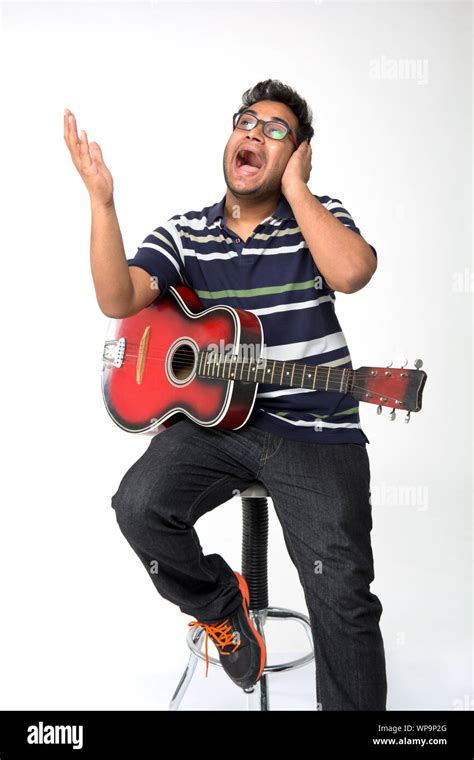 Young man playing a guitar and singing Stock Photo - Alamy