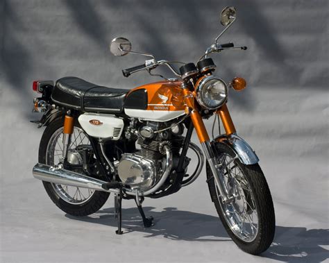 an orange and white motorcycle is parked in the snow