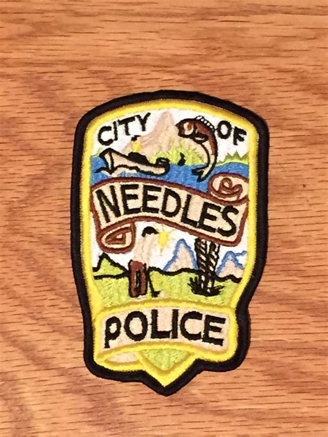 a wooden badge that says city of needles police