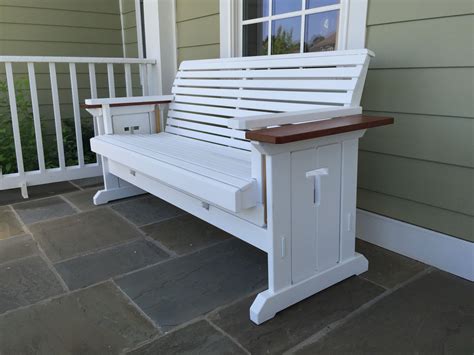 a white bench sitting on top of a stone floor next to a window and door