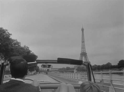 black and white photograph of the eiffel tower in paris, from inside a car