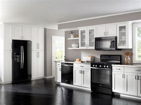 a kitchen with white cabinets and black appliances