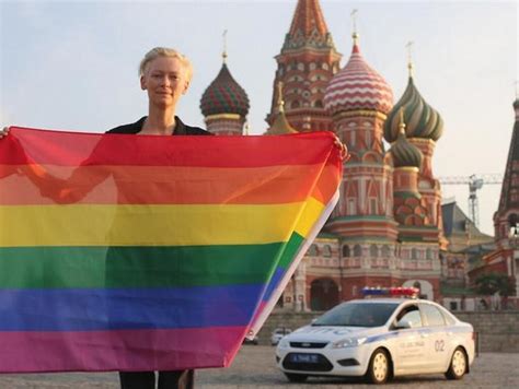 All This Is That: Tilda Swinton with rainbow flag in front of St. Basil's