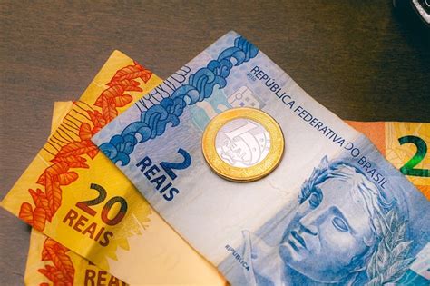 Premium Photo | Brazilian real banknotes and coin on wooden table in ...