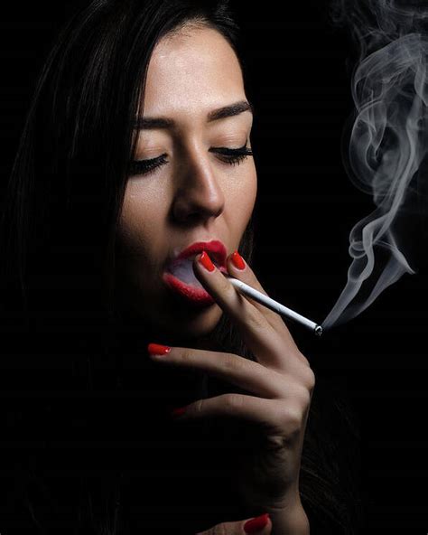 Portrait of the beautiful elegant girl smoking cigarette on black background. Poster by Ivan Dragiev