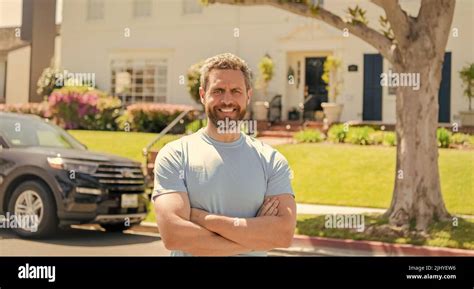 cheerful salesman presenting suburb house and car. broker Stock Photo ...