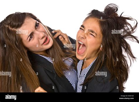 Horizontal close up portrait of angry teenage school girls pulling each ...