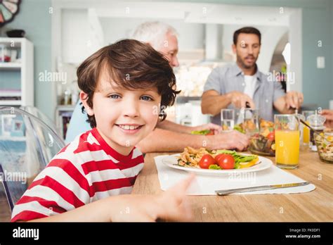 Portrait of smiling boy sitting at dining table Stock Photo - Alamy