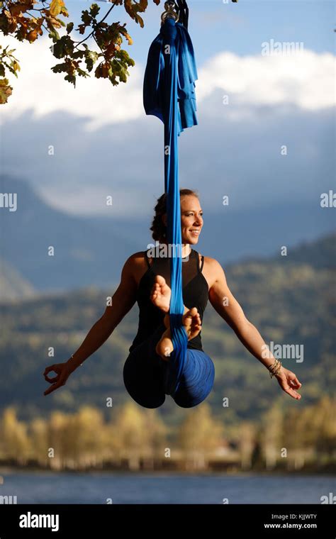 Woman doing pose of aerial yoga using hammock outdoors. Saint-Gervais ...