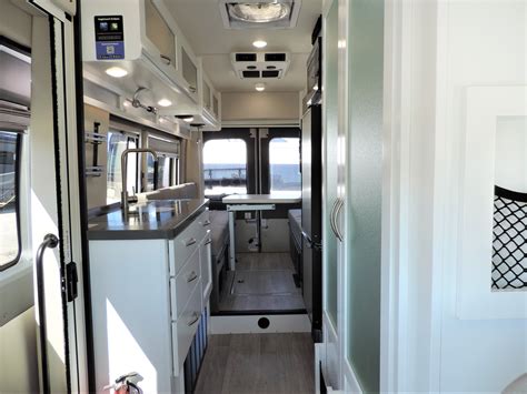 the interior of an rv with white cabinets and black counter tops