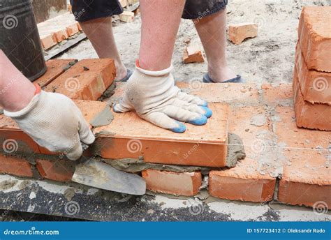 Bricklayer Using a Trowel To Lay New Red Brick House Wall Outdoor. Bricklaying Basics Masonry ...