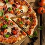Pizza with mozzarella cheese on a wooden table Stock Photo by ©ekizv 65886847