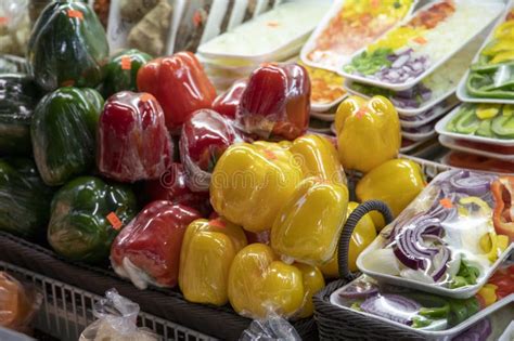 Green, Yellow, and Red Bell Peppers Wrapped in Plastic on Display in Baskets at the Municipal ...