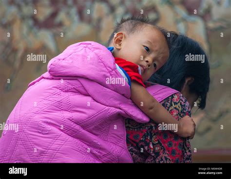 North Korean woman carrying a skinny boy on her back, North Hwanghae Province, Sariwon, North ...