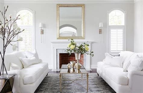 Transitional white living room boasts white roll arm sofas adorned with ...