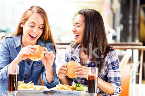 Friends Eating Burgers At Fast Food Cafe Stock Photo | Royalty-Free | FreeImages